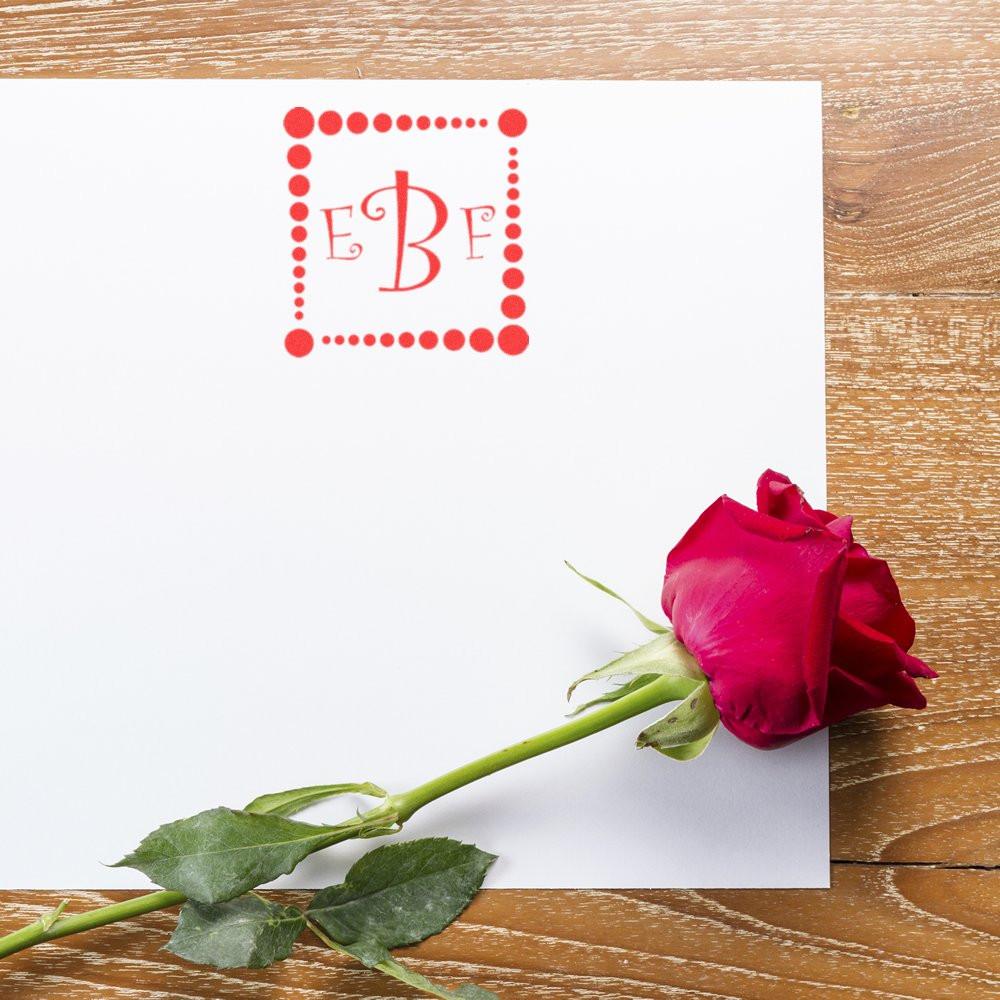 Custom monogram rubber stamp on white card with rose, ideal for personalized wedding invitations and stationery.