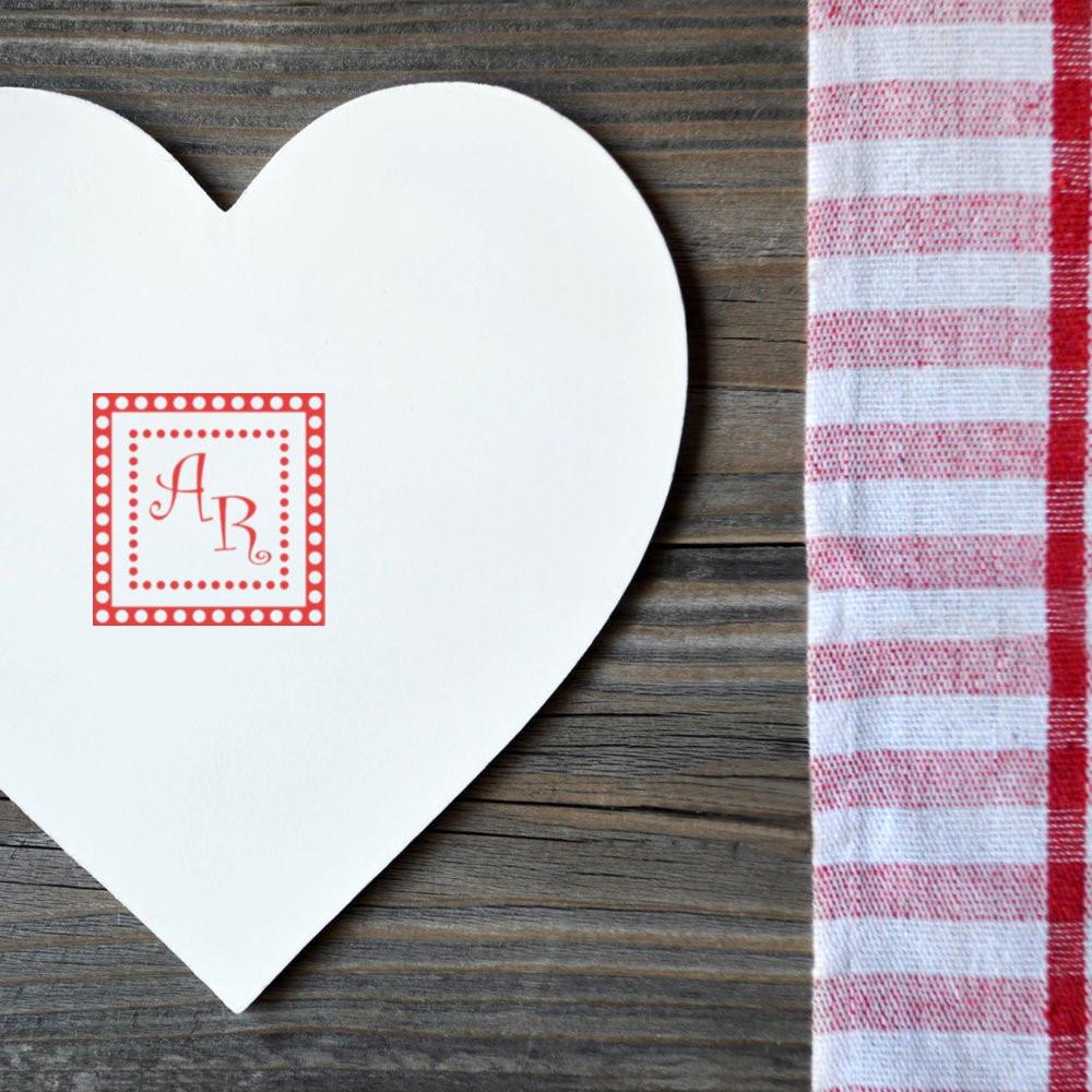 Custom monogram rubber stamp on a heart-shaped card for wedding favors, handmade stationery, and craft projects.