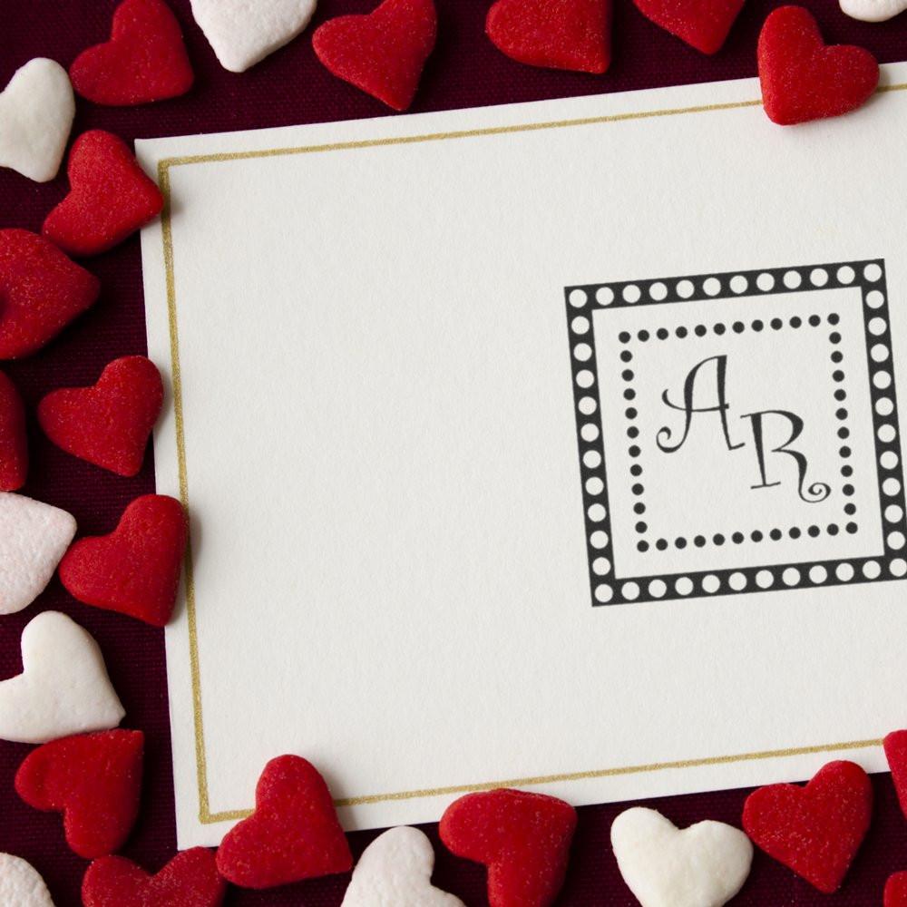 Personalized monogram rubber stamp on a Valentine card, bordered by red and white hearts for romantic stationery.