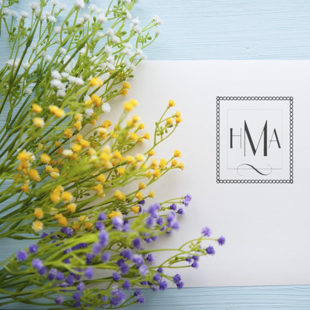 Custom monogram rubber stamp design with HMA in a decorative square border on elegant floral stationery.