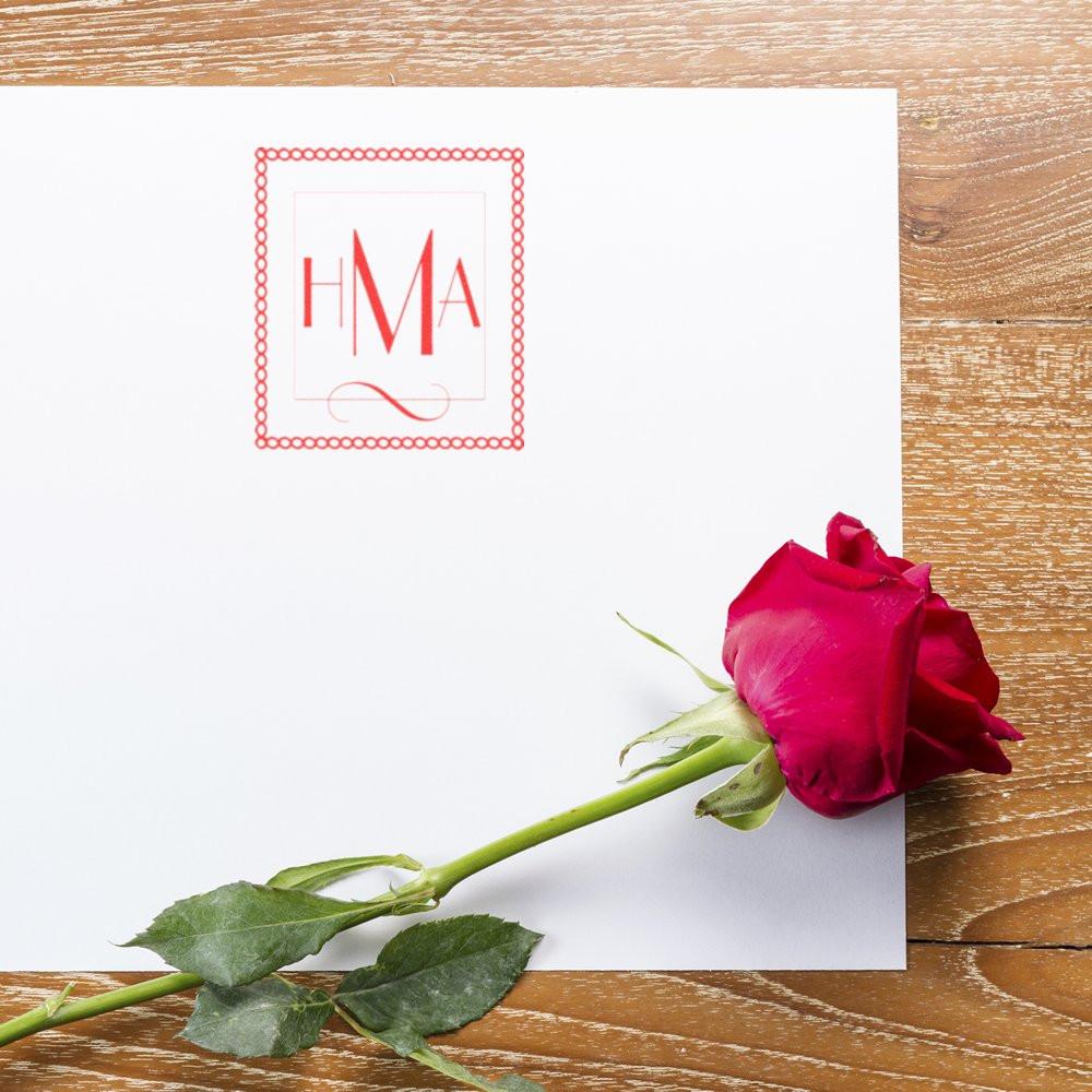 Personalized HMA monogram rubber stamp on white wedding stationery with a red rose, ideal for invitations and gift packaging.
