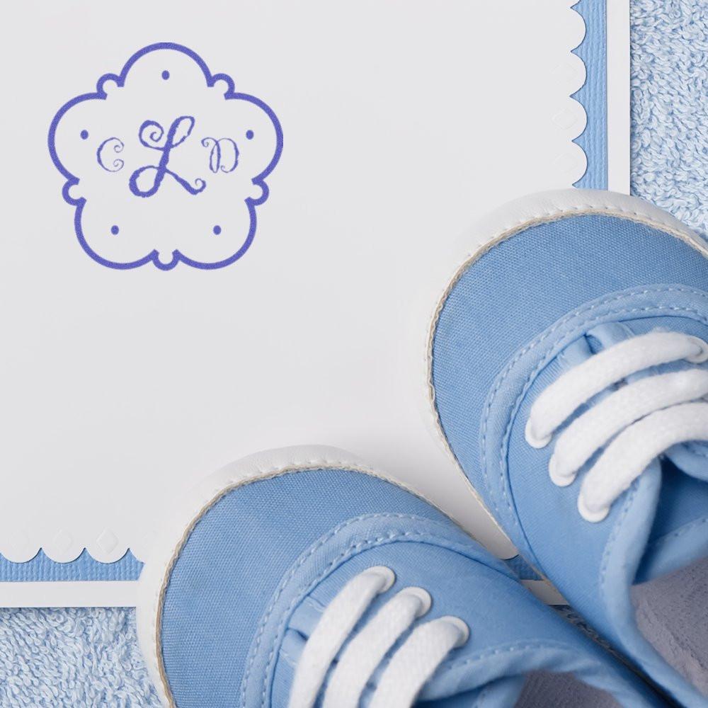 Blue monogram rubber stamp on baby announcement card with soft blue shoes, perfect for personalized stationery and DIY crafts.