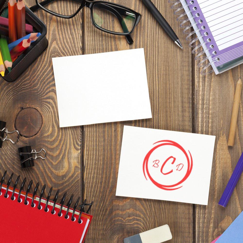 Custom rubber stamp logo on blank stationery and desk supplies, showing branded office stamping for business use.