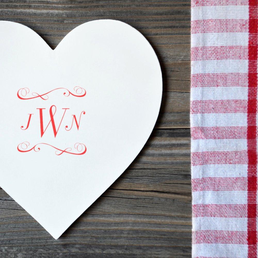 Custom monogram rubber stamp imprint on a heart-shaped card with red JWN initials for wedding stationery.