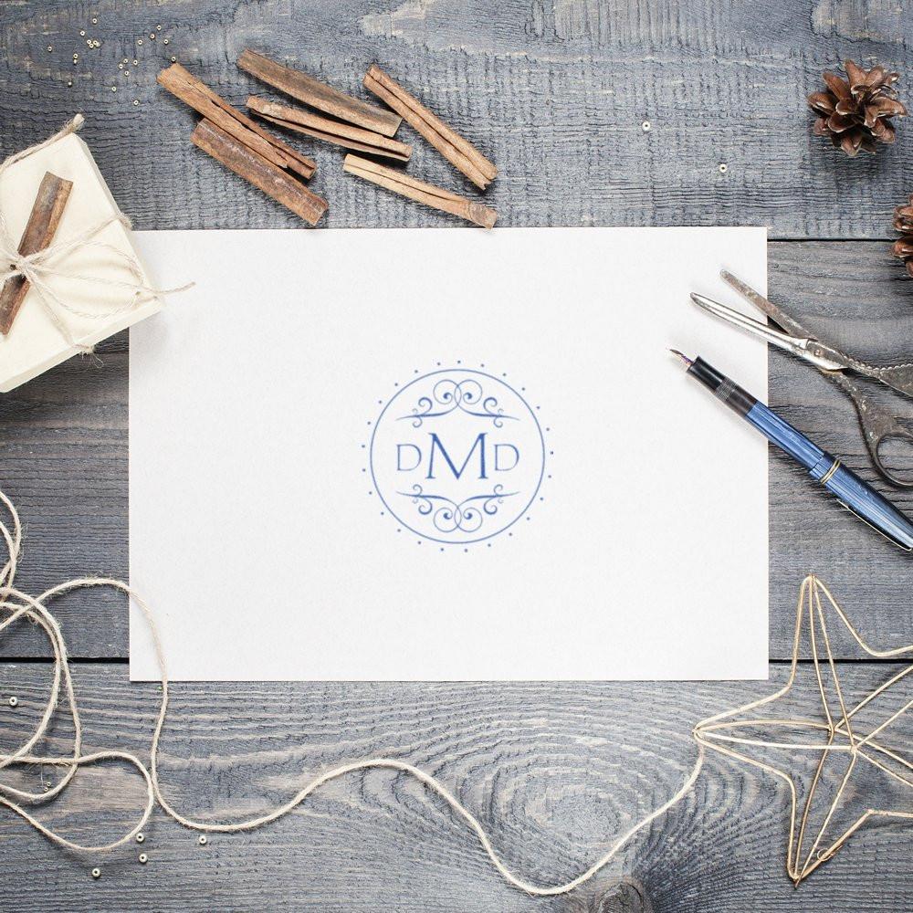 Custom monogram rubber stamp with DMD logo on white stationery, styled with rustic craft supplies and twine.