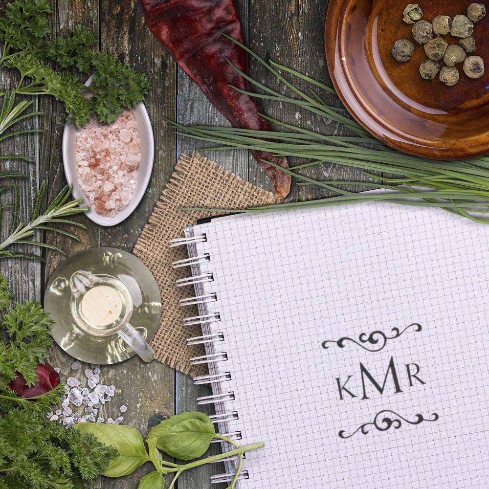 Personalized kMR monogram rubber stamp on graph paper, styled with herbs and spices for custom branding or stationery.