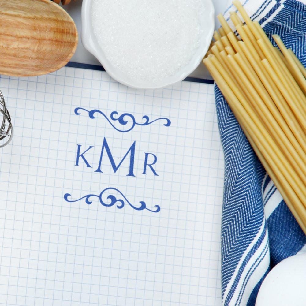 Custom monogram rubber stamp with KMR initials and decorative flourishes on graph paper