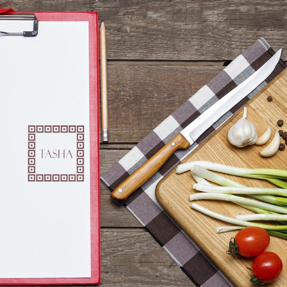 Personalized rubber stamp impression on clipboard, featuring Tasha, beside kitchen prep ingredients and chef knife.