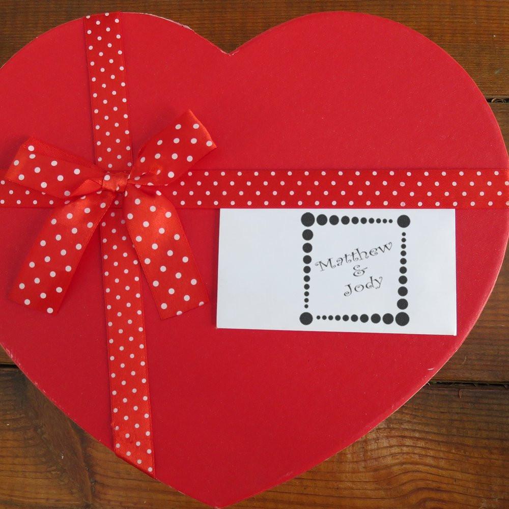 Custom rubber stamp wedding favor tag on a heart-shaped red gift box with red polka dot ribbon.