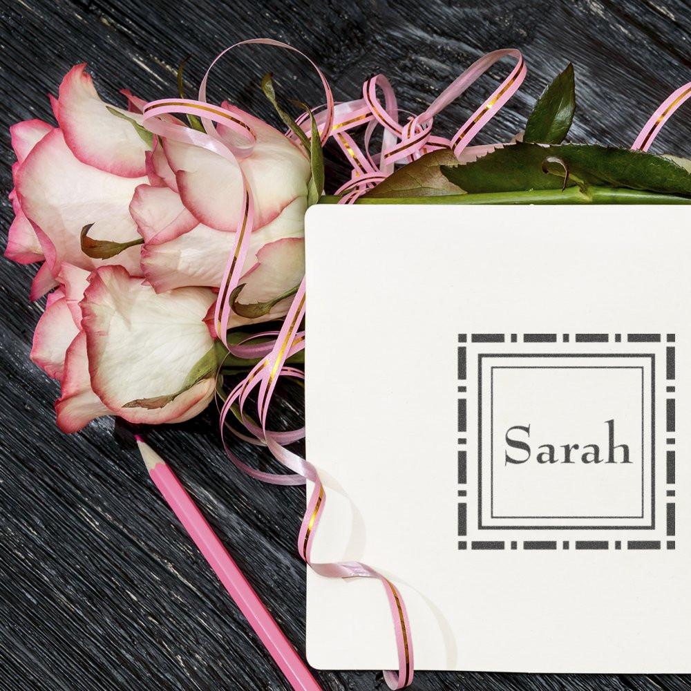 Custom rubber stamp impression with the name Sarah on floral stationery, perfect for personalized cards and crafts.