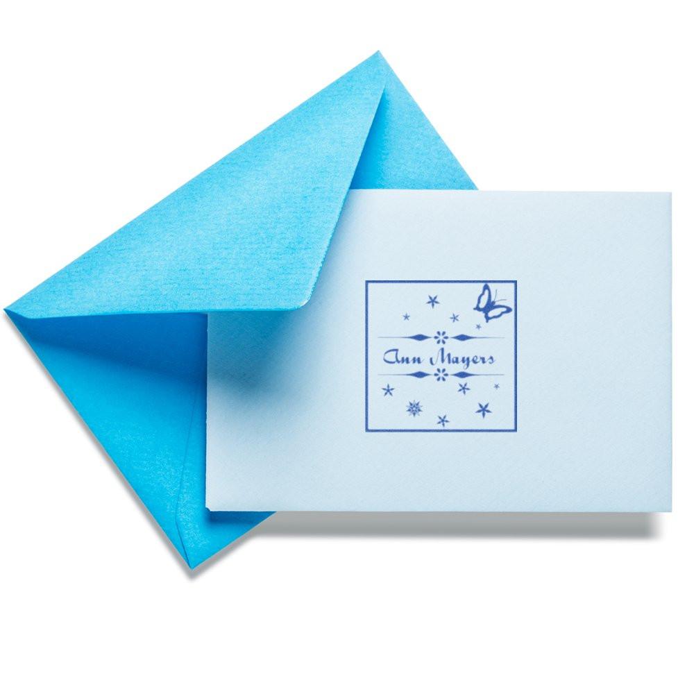 Custom rubber stamp on a card and blue envelope, featuring a butterfly design for personalized stationery and invitations.