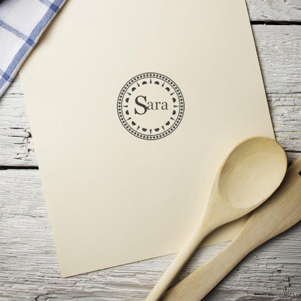 Custom round rubber stamp with Sara name design on stationery, perfect for personalized wedding invitations and branding.