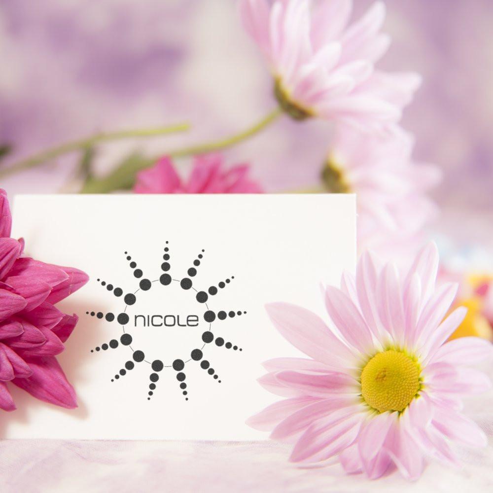 Custom Nicole rubber stamp with floral sunburst logo for personalized stationery and branding