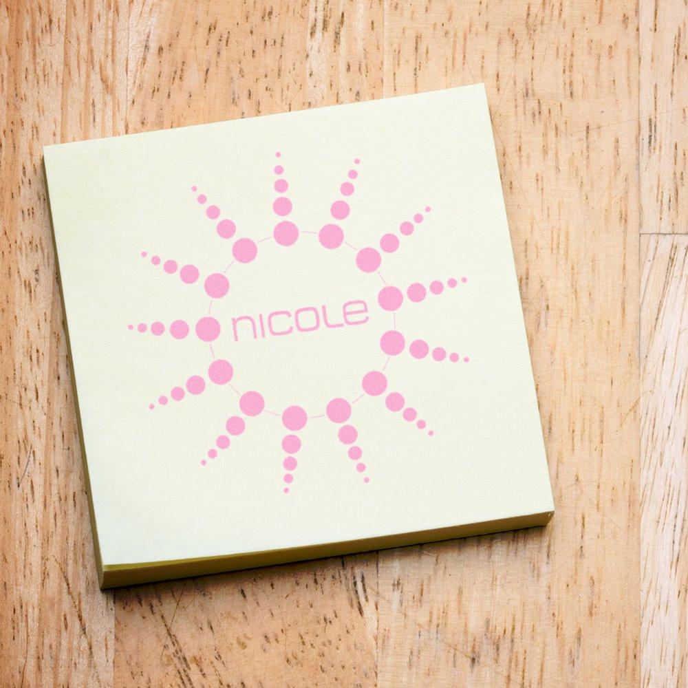 Custom pink rubber stamp for Nicole with circular dot burst design on notepad, ideal for personalized stationery.