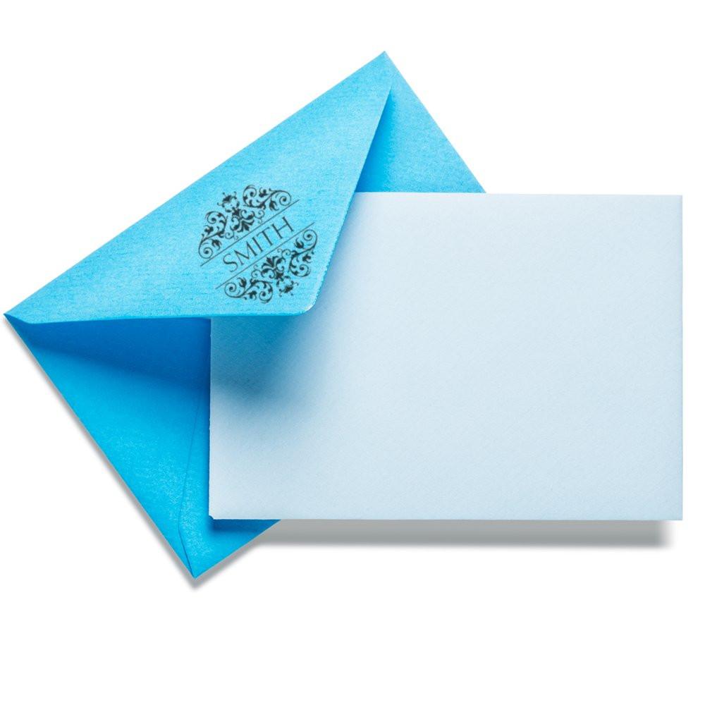 Personalized rubber stamp monogram on blue envelope flap for custom wedding invitations and stationery.