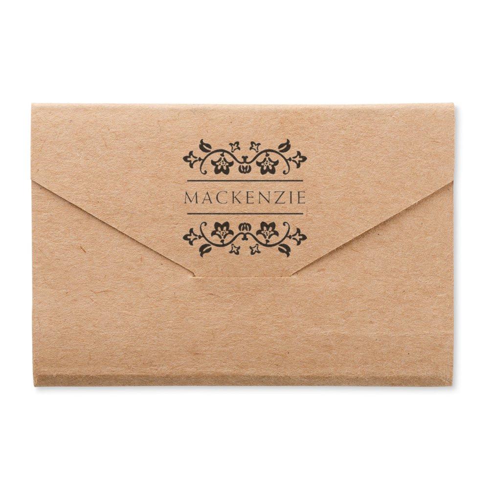 Custom rubber stamp on kraft envelope with floral monogram and MACKENZIE name design for wedding or business branding.
