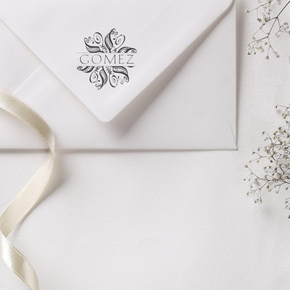 White Gomez stationery envelope with beige ribbon and floral sprigs, ideal for wedding invitations and premium Gomez stationery.