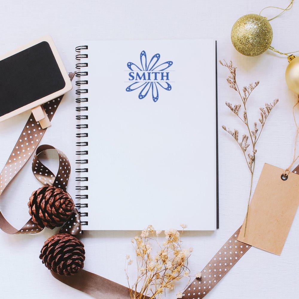 Custom rubber stamp imprint with SMITH logo on notebook, showcasing personalized stationery and branding.