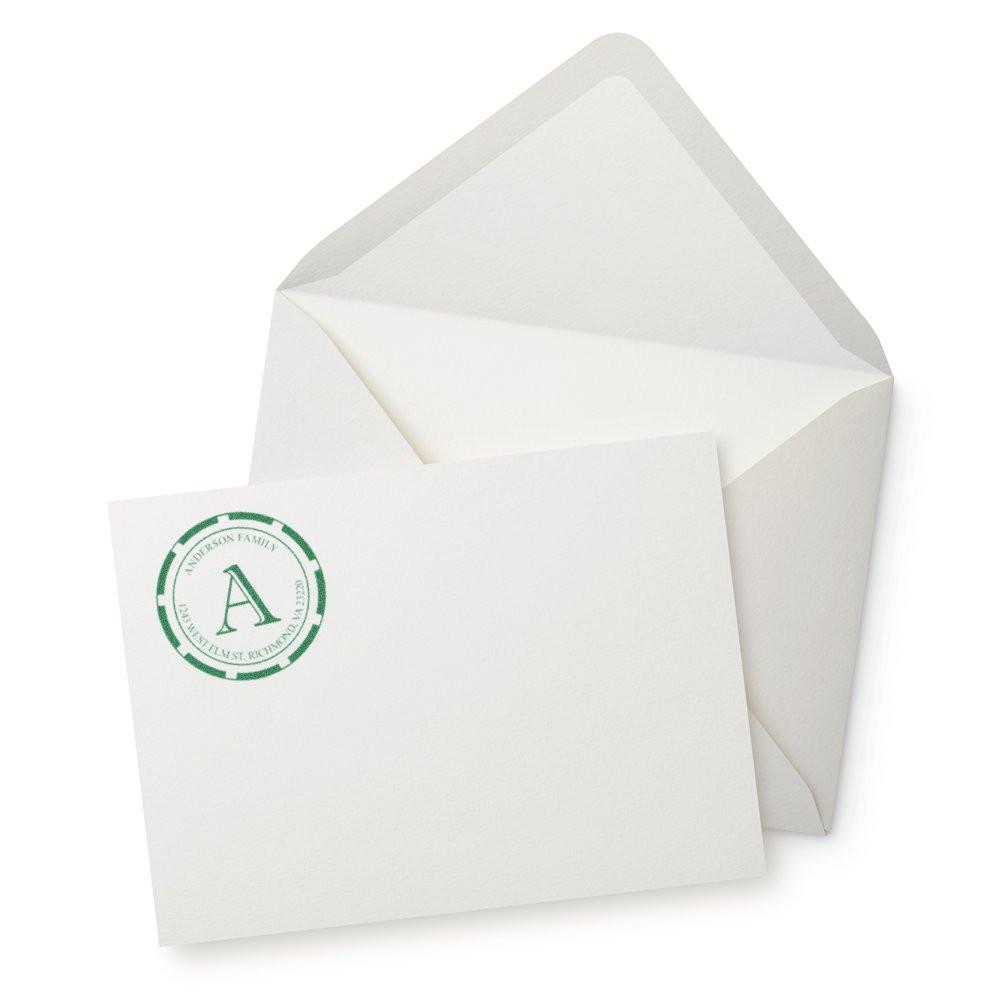 Custom return address rubber stamp with green monogram on white envelope and card, ideal for personalized stationery.