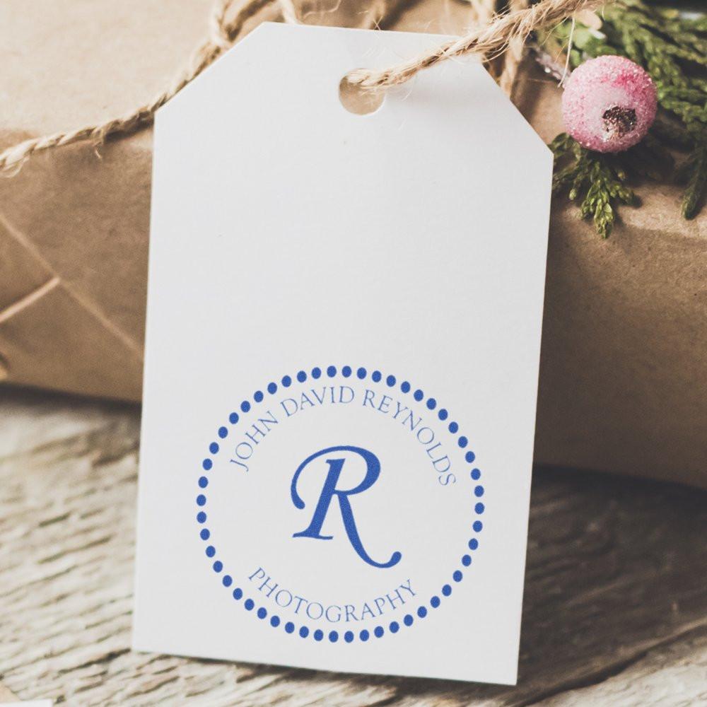 Custom photography logo rubber stamp on a gift tag with John David Reynolds monogram for branded packaging.