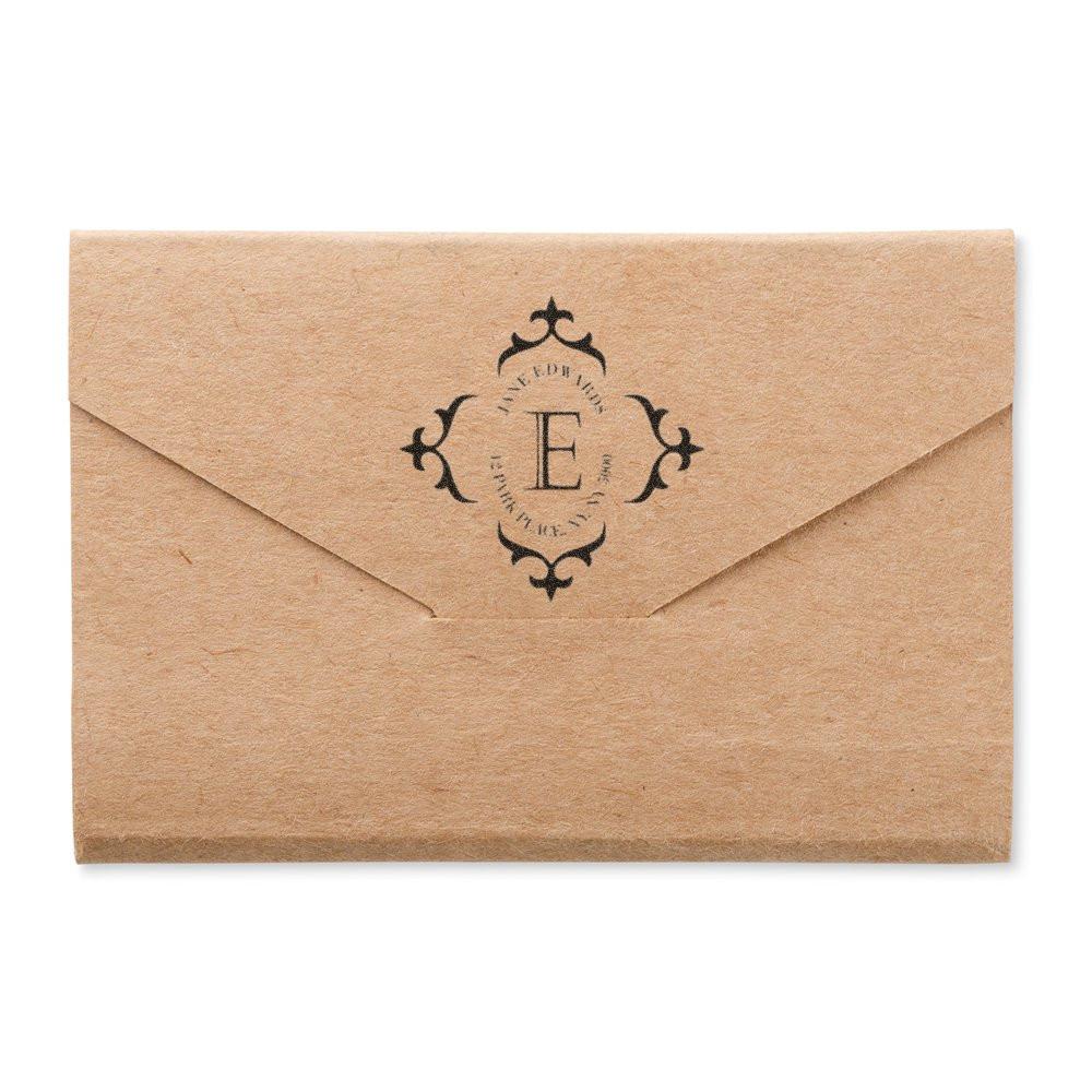 Custom E monogram rubber stamp on kraft envelope for wedding invitations and elegant stationery branding.