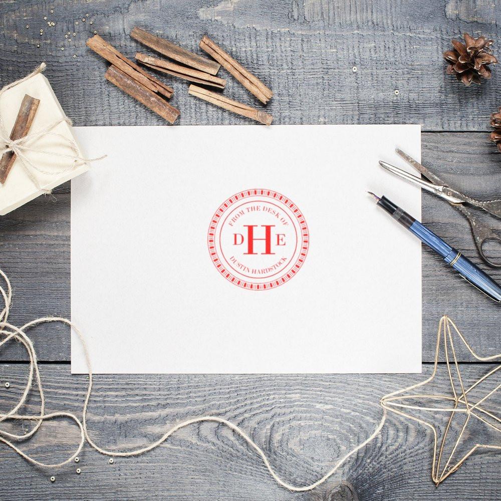 Custom monogram rubber stamp on stationery for personalized letters, business branding, and craft packaging.