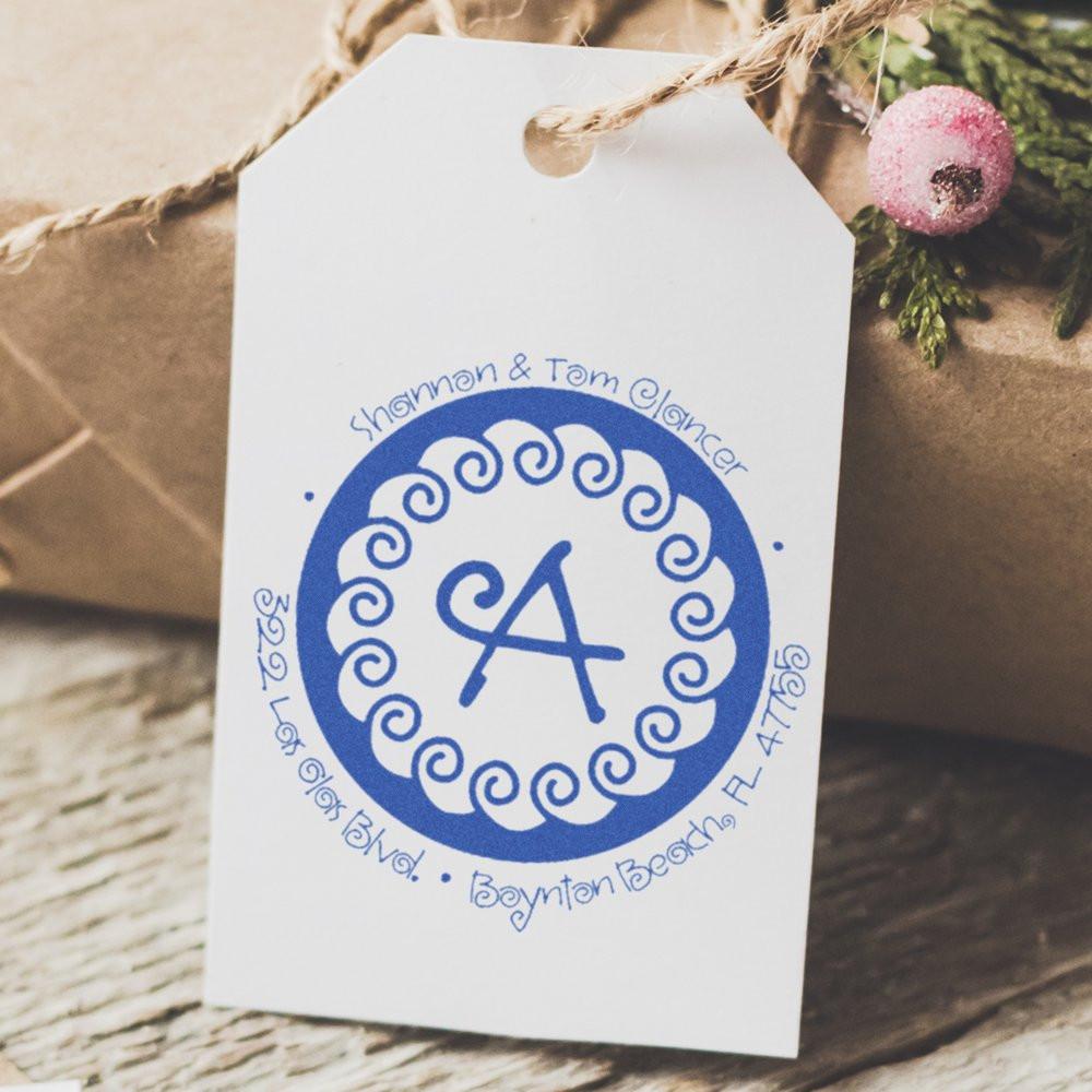 Custom monogram rubber stamp on a gift tag, designed for personalized return address labels and wedding stationery.