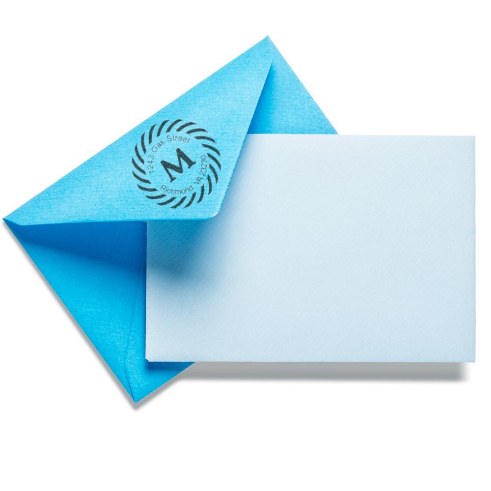 Custom rubber stamp logo on blue envelope with blank card, ideal for branded business mailing and stationery.