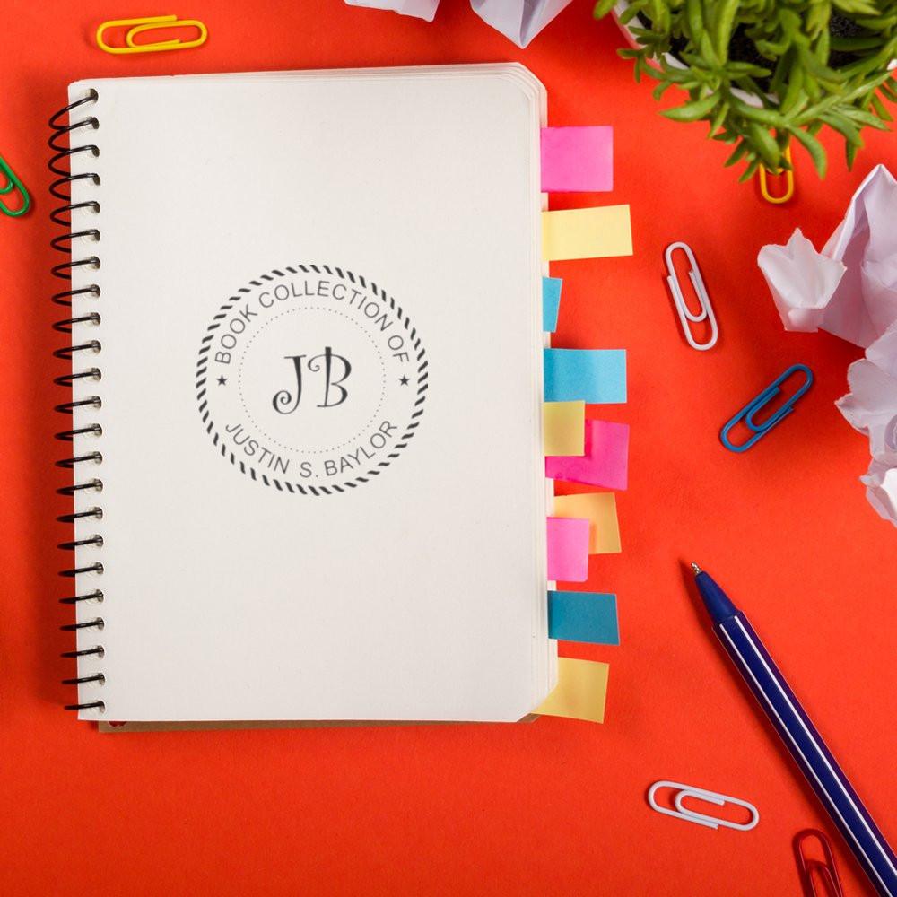 Personalized book collection rubber stamp on notebook for organizing and labeling a personal library.