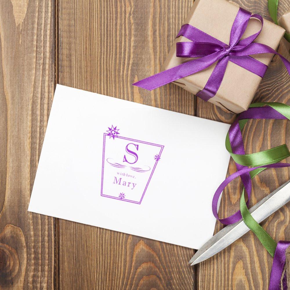 Holiday gift wrapping with ribbons and scissors, showing a personalized greeting card reading S with love, Mary on a wooden table.