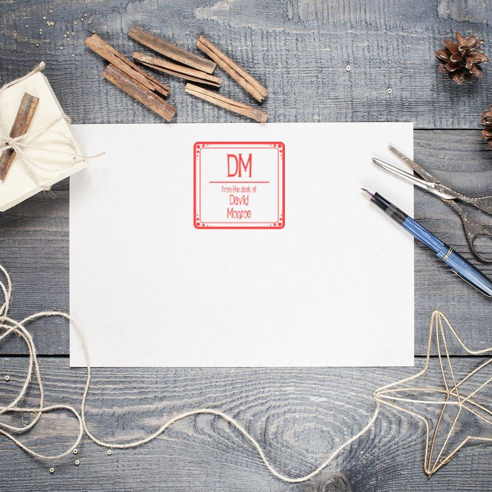Custom rubber stamp mockup with DM monogram on white paper, ideal for personalized stationery