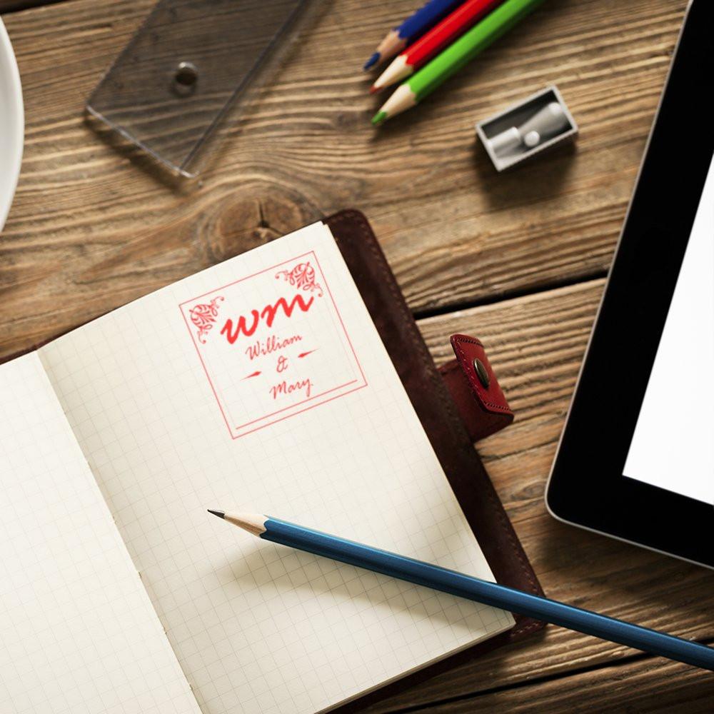 Custom monogram rubber stamp on notebook page, ideal for personalized stationery, wedding favors, and branding.