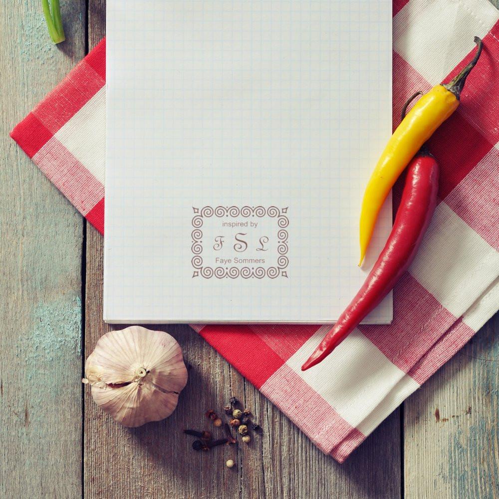 Personalized custom rubber stamp impression on notebook with monogram initials, styled for a rustic culinary brand.