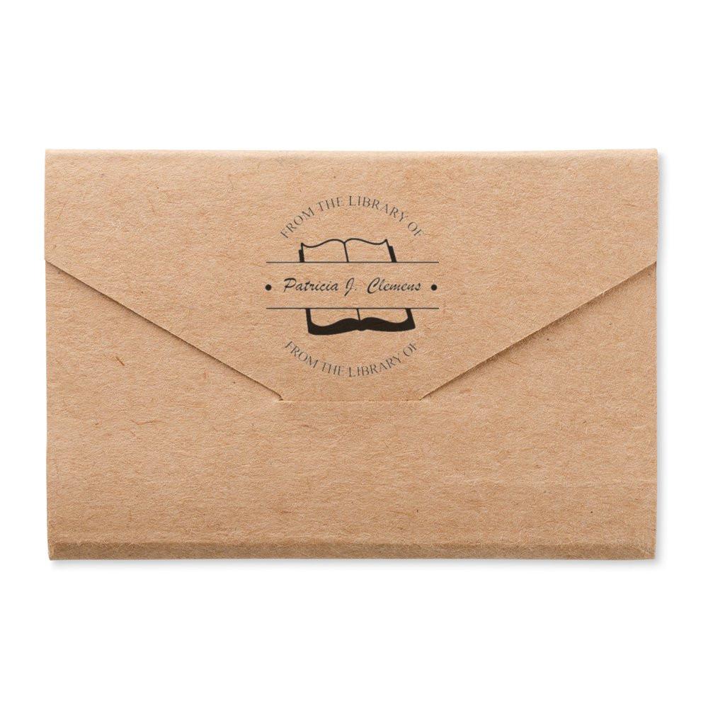 Custom book return rubber stamp on kraft envelope, featuring From the Library of personalized name design for bookplates.