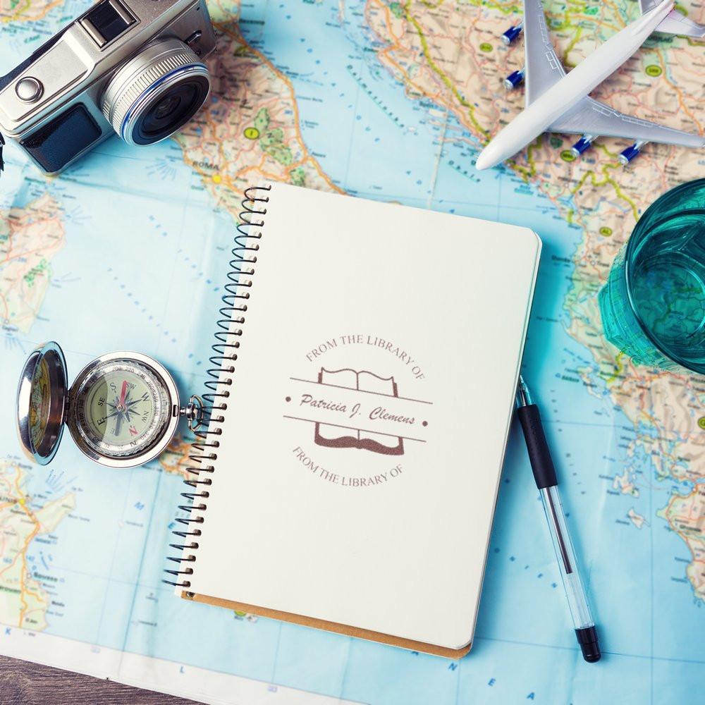 Custom rubber book stamp on a travel journal, ideal for personalized library ownership and book labeling.