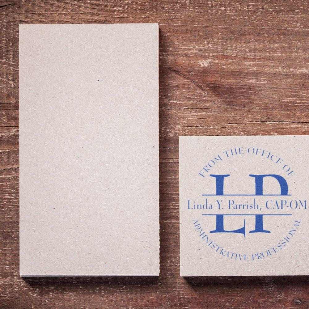 Blank cardstock beside a blue custom rubber stamp impression with monogram and name, showing an administrative professional stamp.