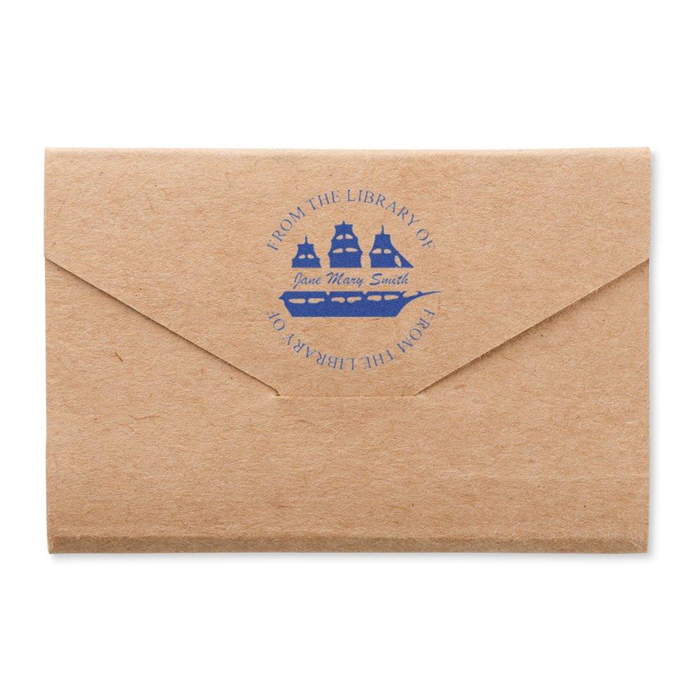 Custom rubber stamp on kraft envelope with personalized From the Library of bookplate and ship design.