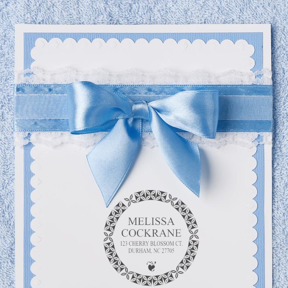 Custom return address rubber stamp design on an elegant blue gift card with satin bow, ideal for wedding invitations.