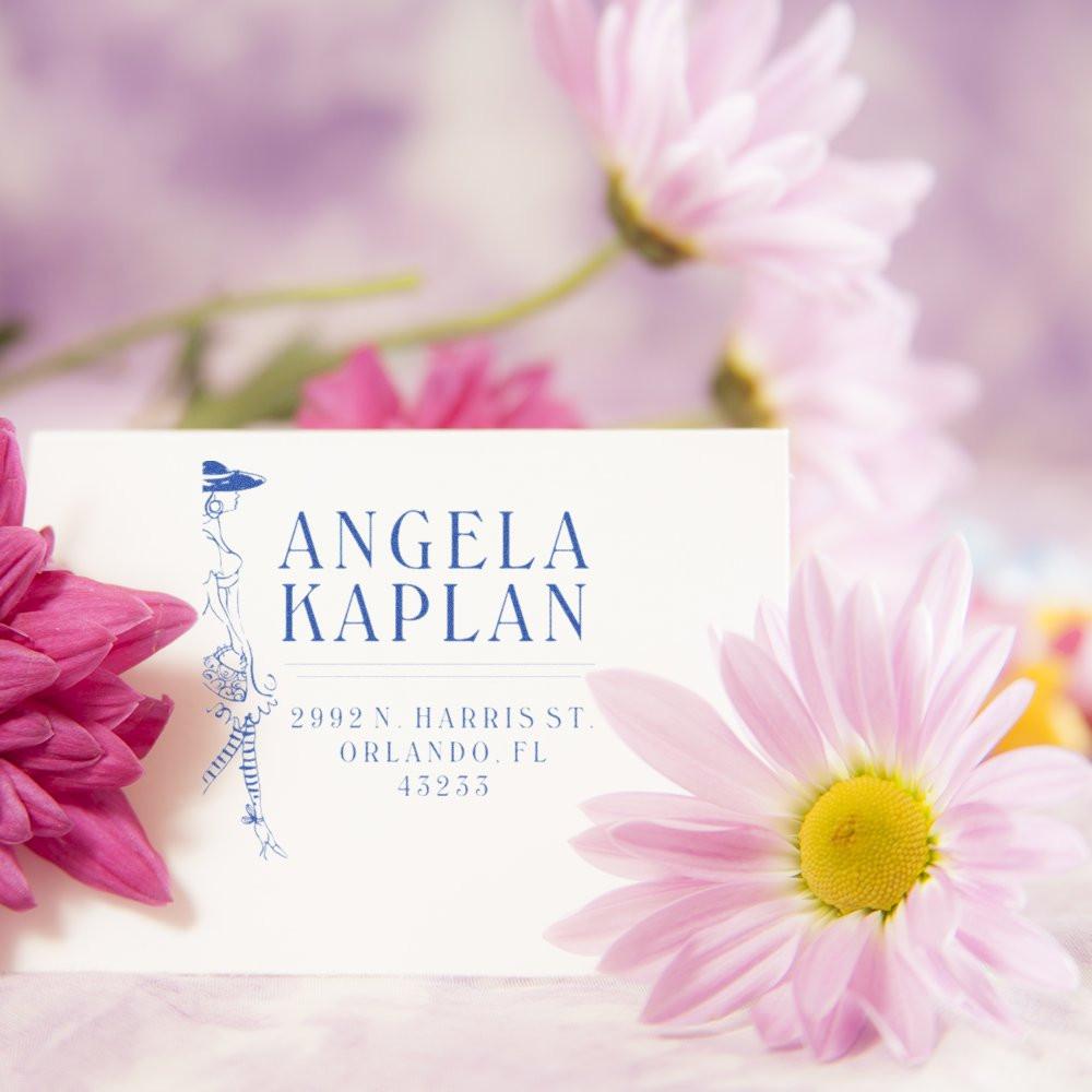Angela Kaplan business card with address in Orlando, FL, over pink flowers and soft pastel background.