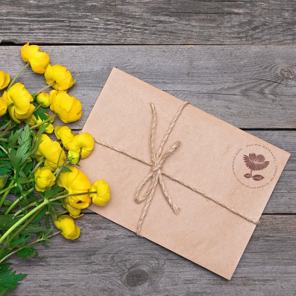 Custom floral rubber stamp on kraft paper packaging tied with twine for eco-friendly business branding.