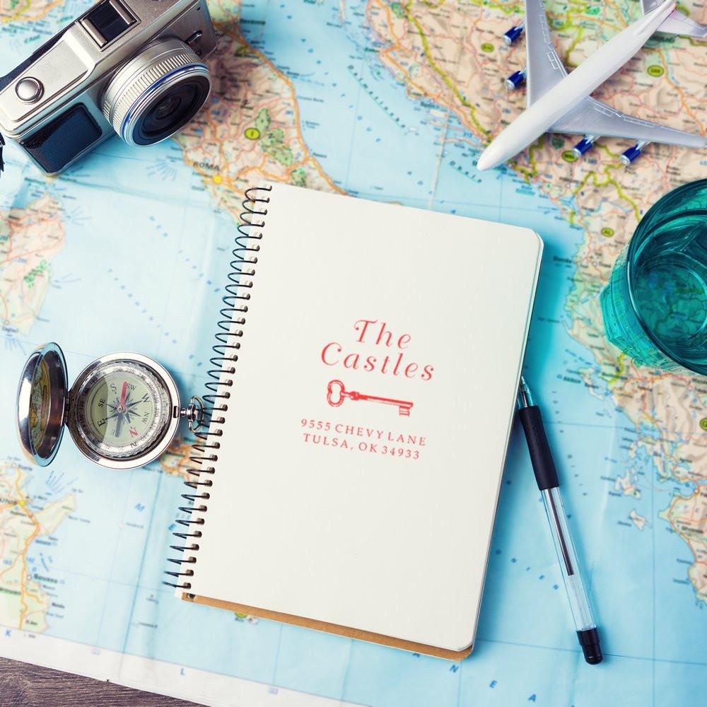 Custom return address rubber stamp on a travel notebook, perfect for personalized stationery and mailing.