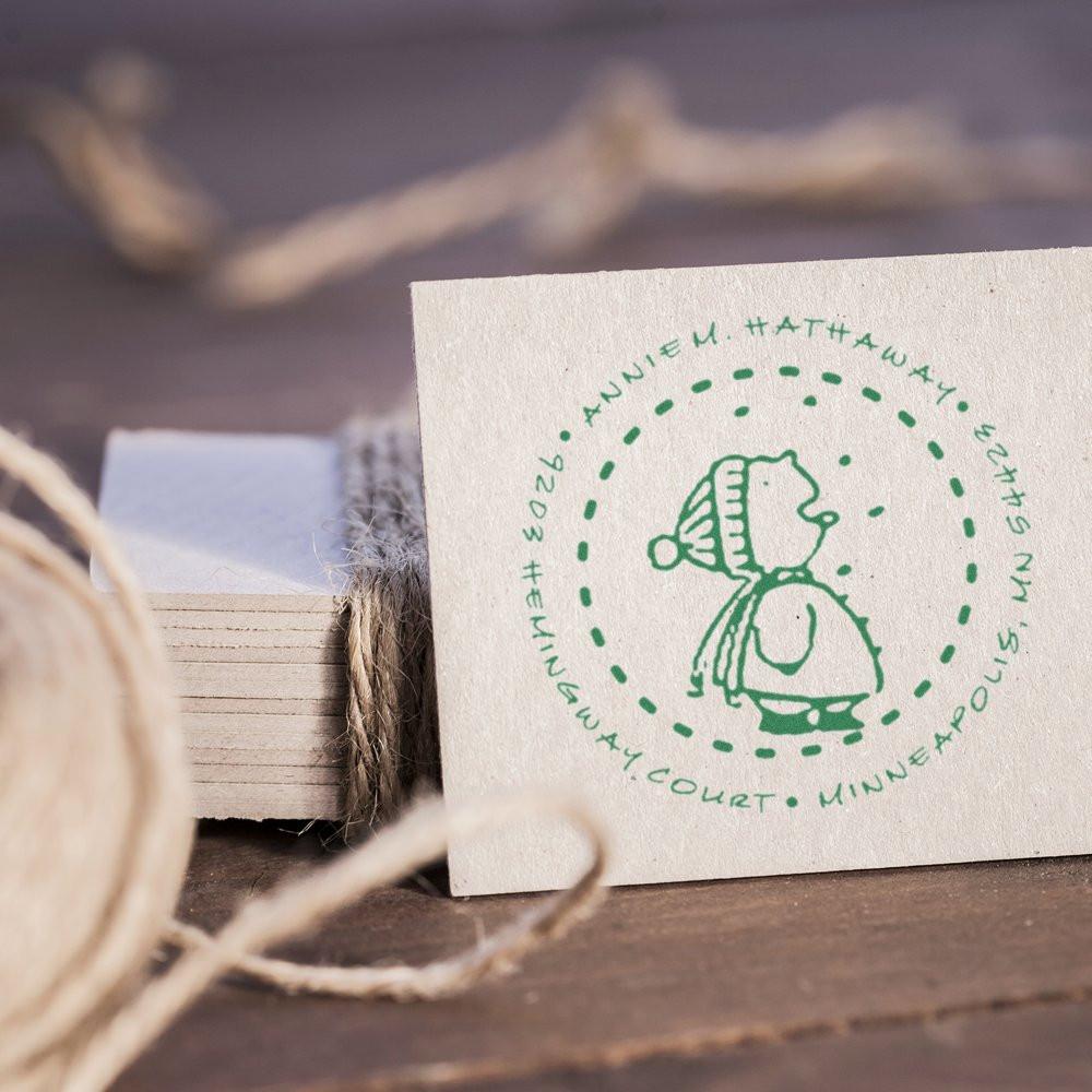 Green custom rubber stamp impression on kraft paper, showing a handmade winter logo for branding, packaging, and stationery.