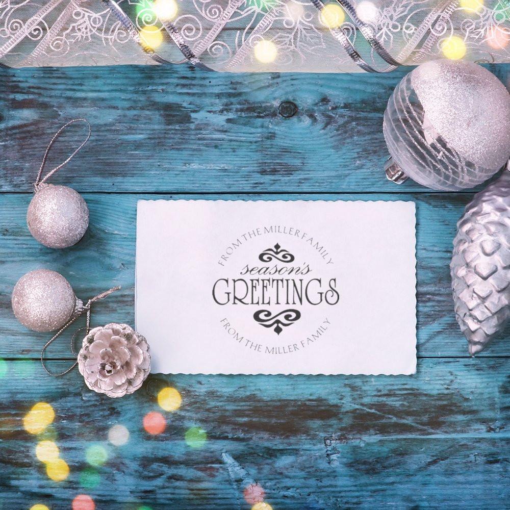 Personalized rubber stamp holiday card reading Seasons Greetings from the Miller Family with silver Christmas ornaments.