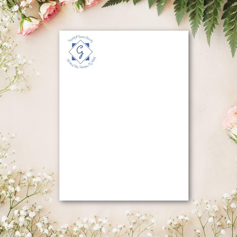 Custom rubber stamp logo mockup on blank stationery card with floral border for personalized business branding.