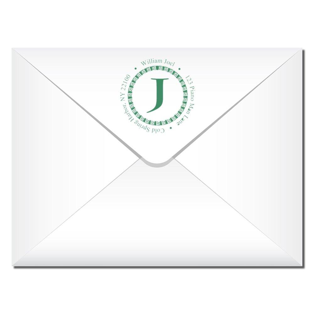 Custom return address rubber stamp on envelope with monogram J and circular name-and-address design.