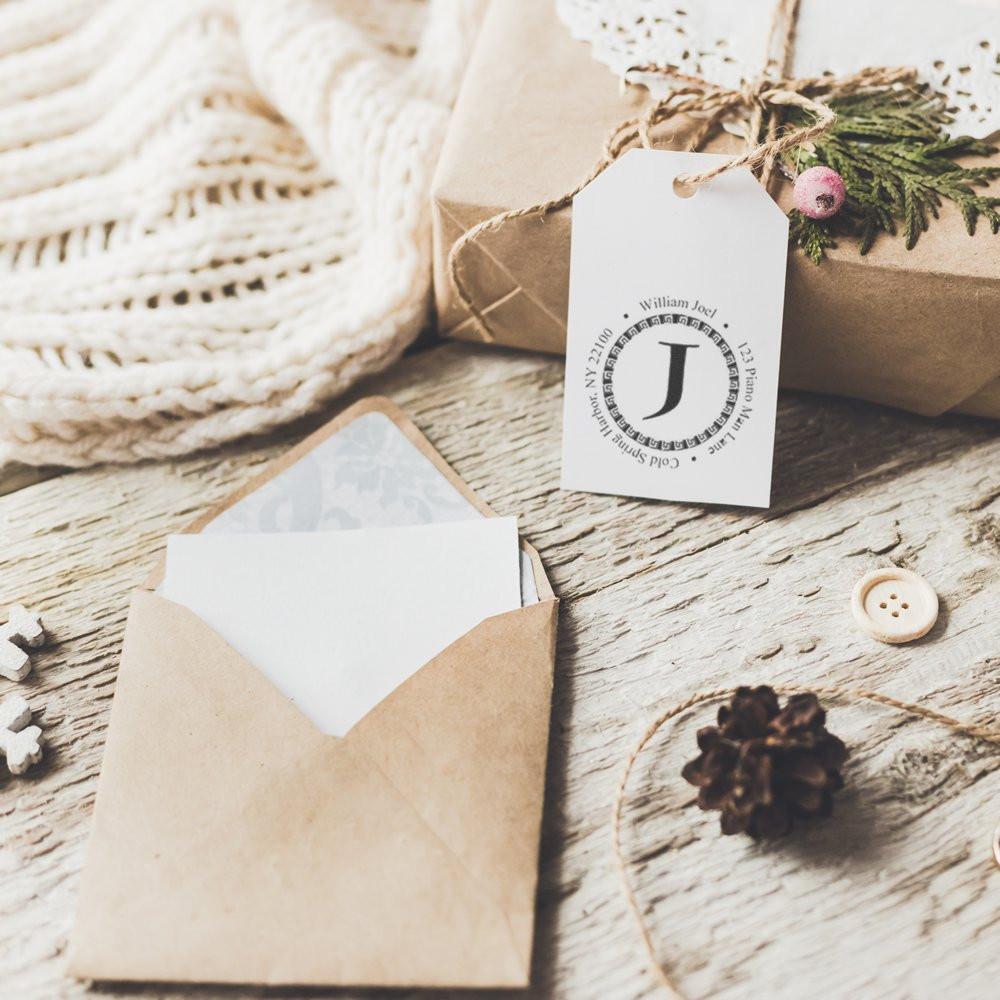 Personalized rubber stamp monogram gift tag with rustic envelope, ideal for custom stationery, branding, and packaging.