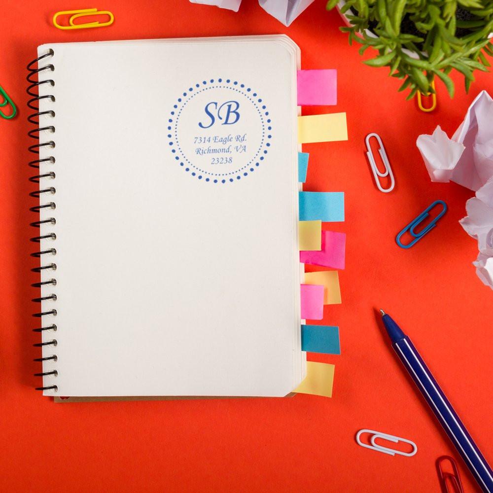 Custom address rubber stamp on notebook cover, ideal for personalized stationery, business branding, and mailings.