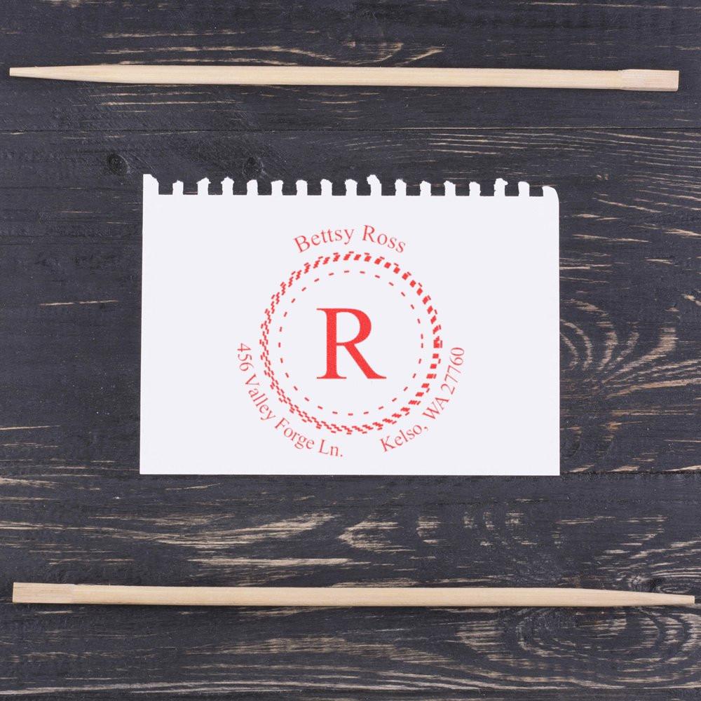 Personalized return address rubber stamp with monogram R and circular red imprint, shown with wooden stamp handles.