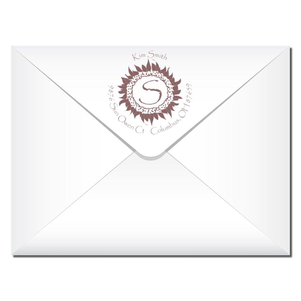 Custom return address rubber stamp on envelope with sunflower monogram for wedding invitations and personalized stationery.