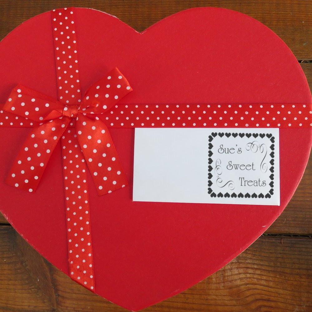Personalized rubber stamp label on heart-shaped gift box with red polka-dot ribbon for Sues Sweet Treats.
